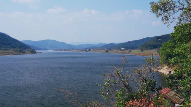 Serene river with mountains in the background on a sunny day