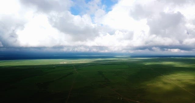 Vast green landscape under cloudy sky