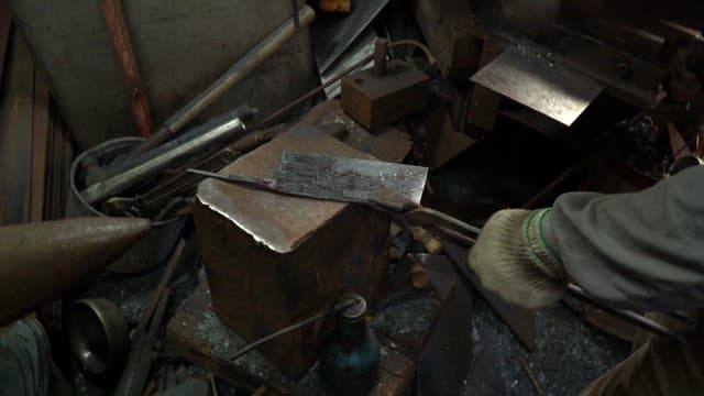 Worker forging metal in a workshop
