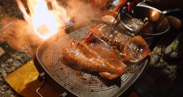Sizzling squid being cooked on a grill