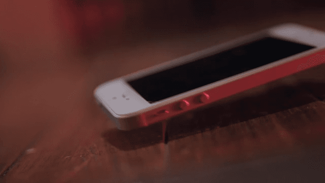 Smartphone dropped on dark wooden floor