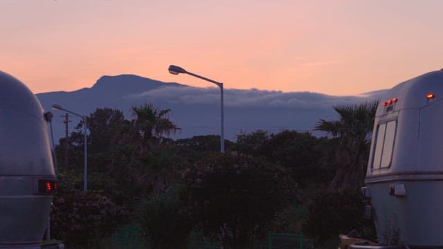 Mountains and sky at dusk seen between campers