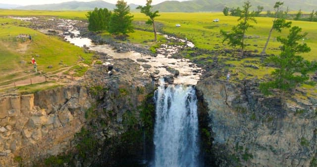 Scenic waterfall in a vast green landscape