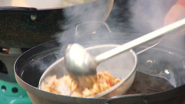 Removing the golden and crispy pork from the oil