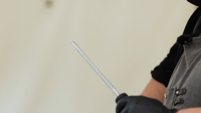 Person cutting raw meat outdoors