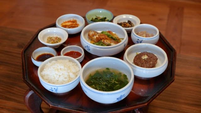 Traditional Wooden Table with Korean Side Dishes such as Stewed Fish and Tteokgalbi