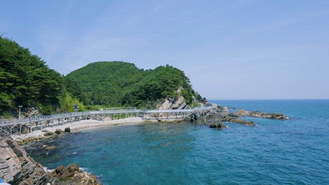 Serene and Clear Seaside with a Hillside Promenade during the Daytime