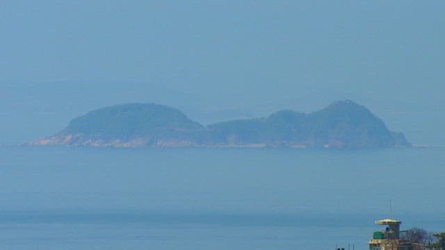 Tranquil View of a Distant Island Over Sea