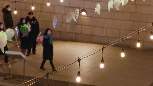 People enjoying the colorful lanterns that light up cheonggyecheon stream