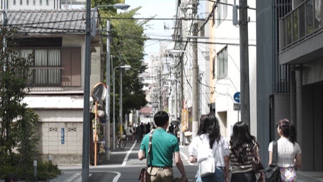 Four People Walking Down an Residential Alley