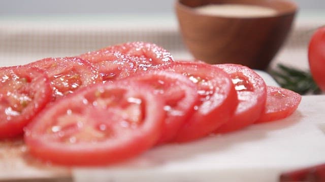 Sliced Tomatoes Being Sprinkled with Sugar