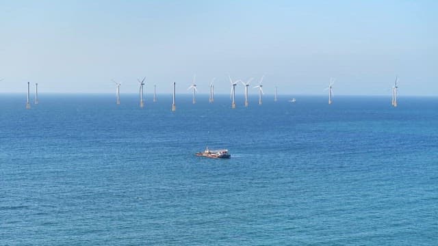 Wind turbines and a boat on the ocean