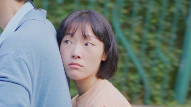 Two people, riding a bike outdoors on a sunny day