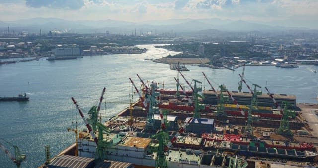 View of a shipyard in Ulsan with cranes and ships from day to night
