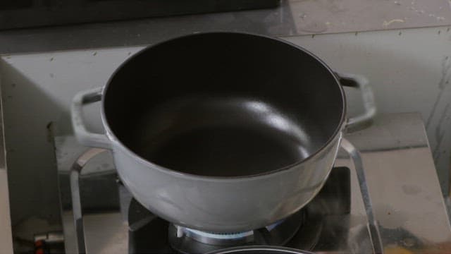 Pouring oil into a hot pan to fry vegetables