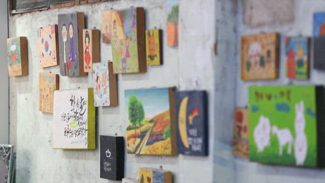 Wall adorned with various colorful paintings