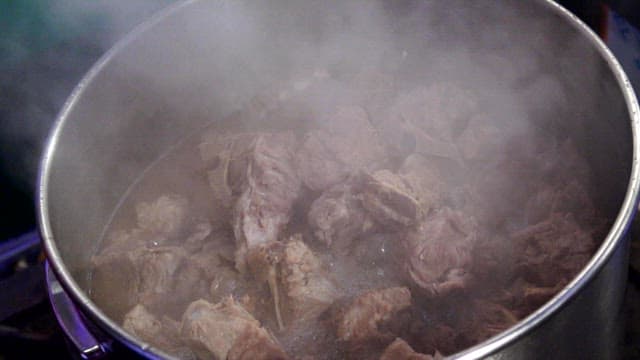 Pork backbones cooking in a sot