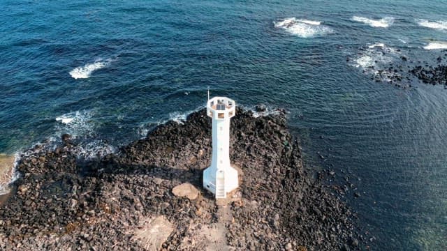 Lighthouse by the rocky seashore