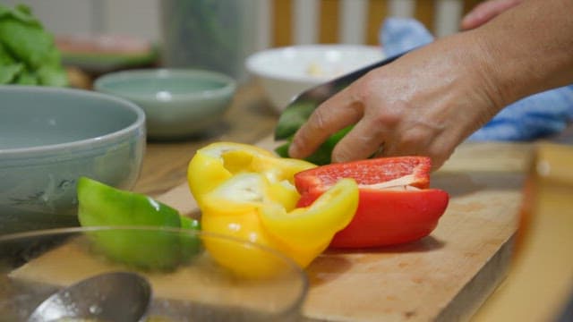 Slicing colorful papricas on a cutting board