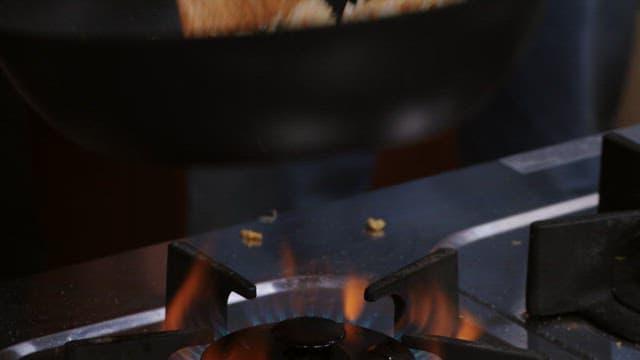 Cooking fried rice in a wok with wooden spatula