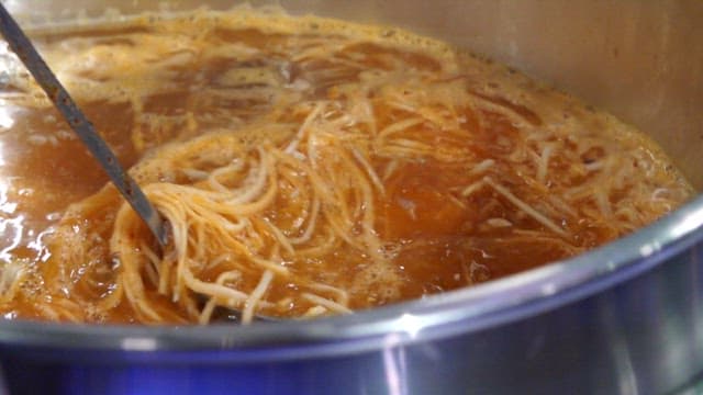 Boiling stew stirring with a ladle