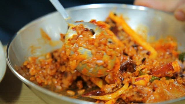 Spoonful of bibimbap with stir-fried squid and pork