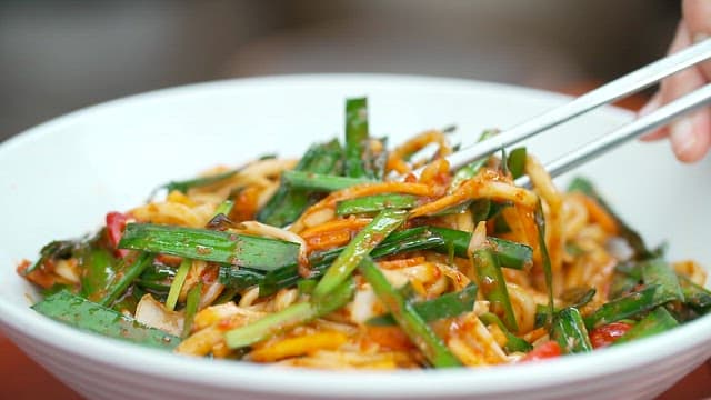 Chopstickful of delicious spicy noodles with chives