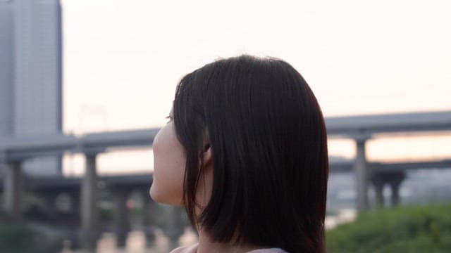 Woman smiling by the riverside at sunset