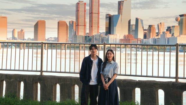 Couple standing by the riverside with cityscape