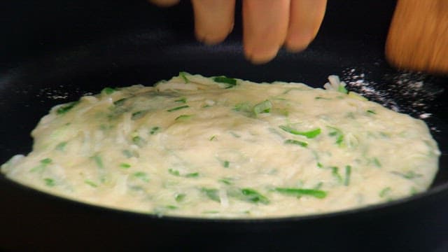 Cooking Korean green onion pancake in a pan