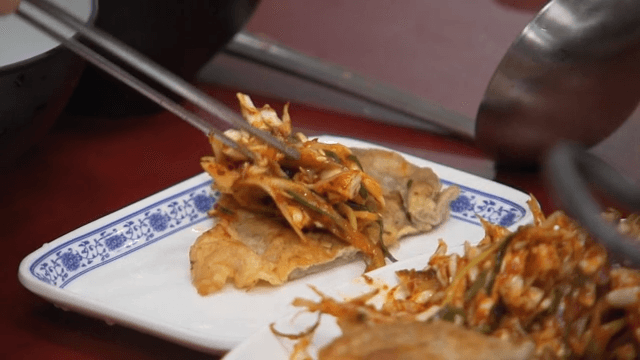 Eating meat pancake with spicy seasoned green onion 