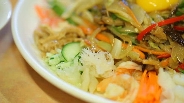 Starch sheet salad with mustard sauce topped with egg yolk