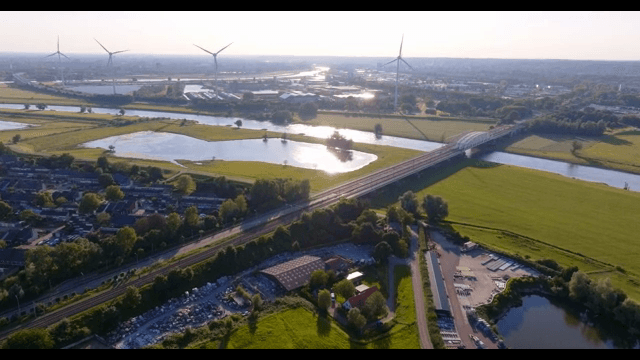Scenic view of a river and wind turbines