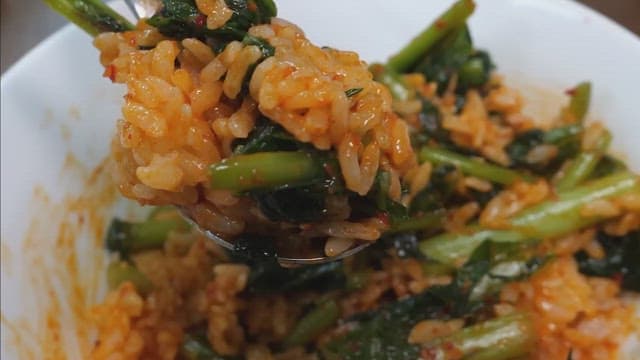Mixing spicy young radish bibimbap in a bowl