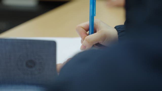 Close-up of Hand of Person Writing in a Notebook