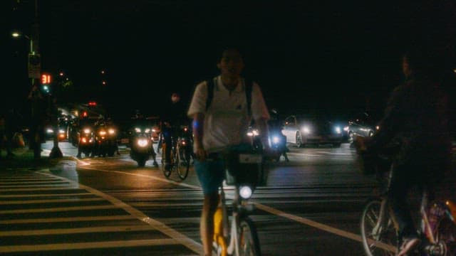 Cyclists and Vehicles at a Nighttime Crossing