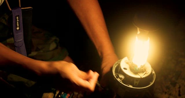 Lighting a Lantern at Night Outdoors