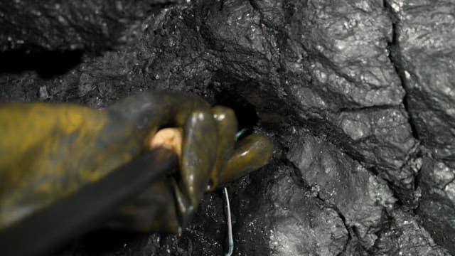 Worker placing explosive charges in a coal mine