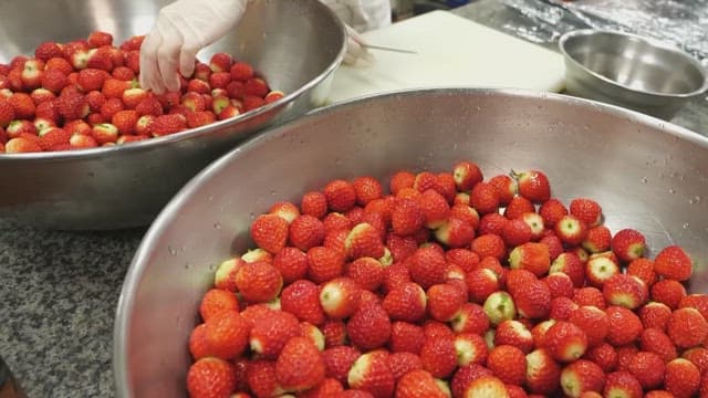 Strawberries waiting to be prepared in a stainless steel bowl