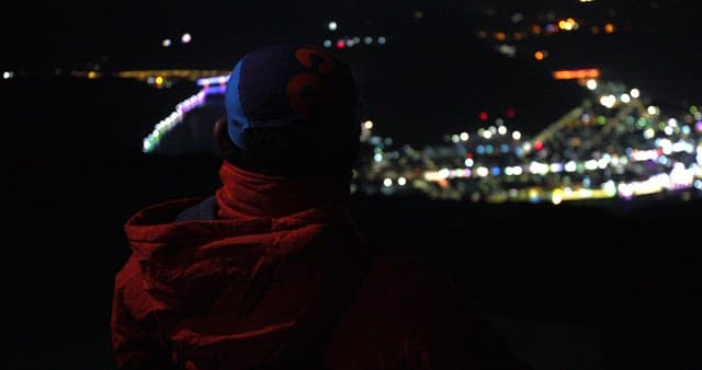 Man Overlooking City Lights at Night
