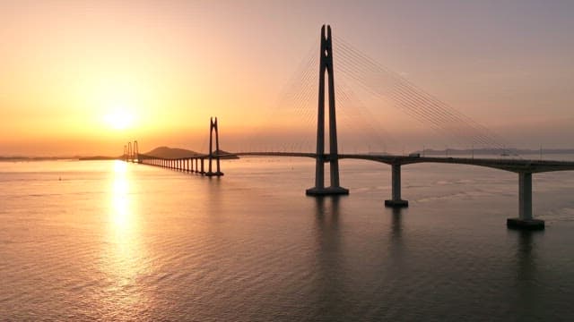 Bridge over calm waters at sunset