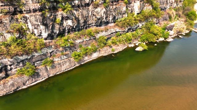 Serene river flowing beside rocky cliffs
