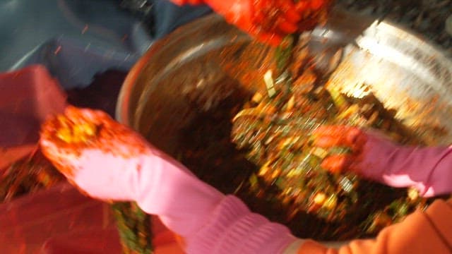 Transferring well-seasoned green onion kimchi into a kimchi container