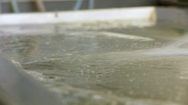 Stainless steel autopsy table being washed in water
