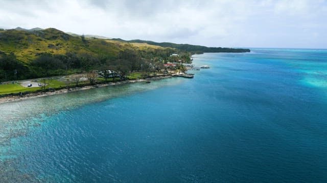 Coastline where Emerald Sea Meets Green Mountains
