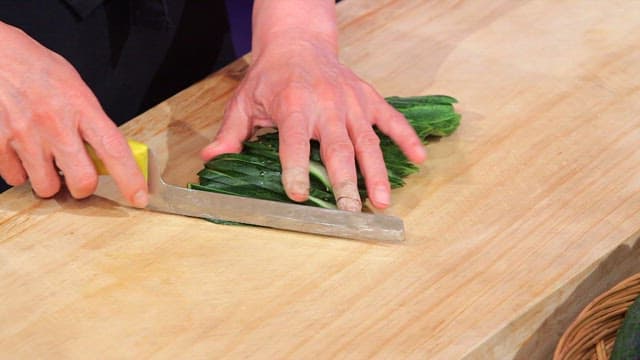 Slicing fresh cucumbers on a wooden cutting board