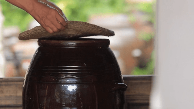 Hand covering a traditional Korean jar