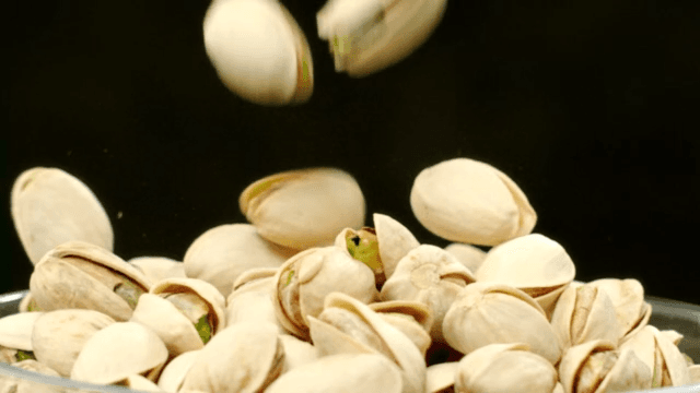 Falling pistachios on black background