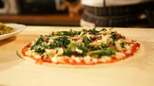 Preparing homemade fusion pizza with fresh ingredients