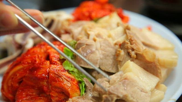 Pick up the boiled pork with chopsticks and place it on the rice